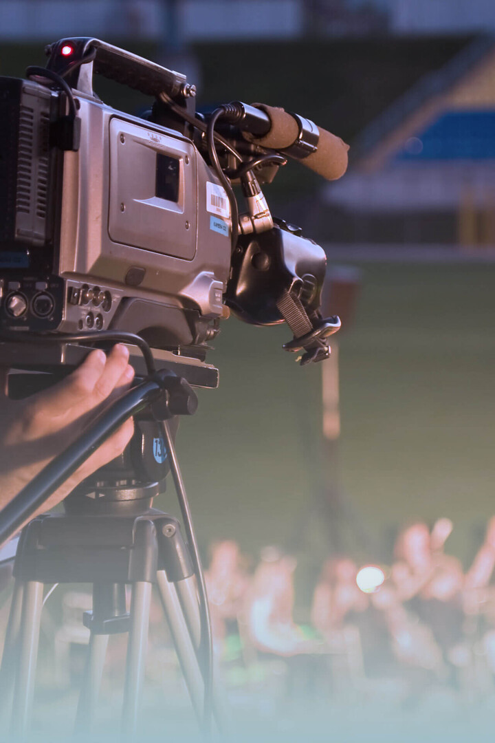 Kameramann filmt ein Event im Stadion mit professioneller Kamera.
